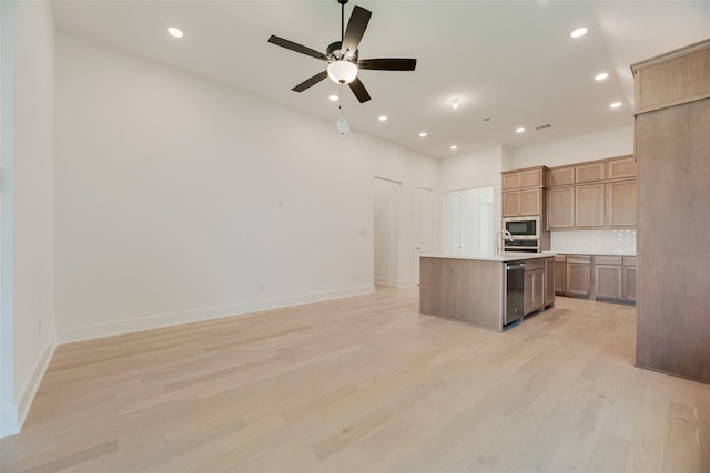 kitchen featuring open floor plan, decorative backsplash, built in microwave, and ceiling fan