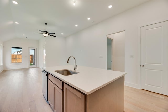 kitchen featuring light wood-type flooring, a sink, open floor plan, and stainless steel dishwasher