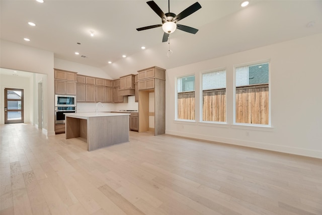 kitchen with vaulted ceiling, light countertops, stainless steel appliances, and recessed lighting
