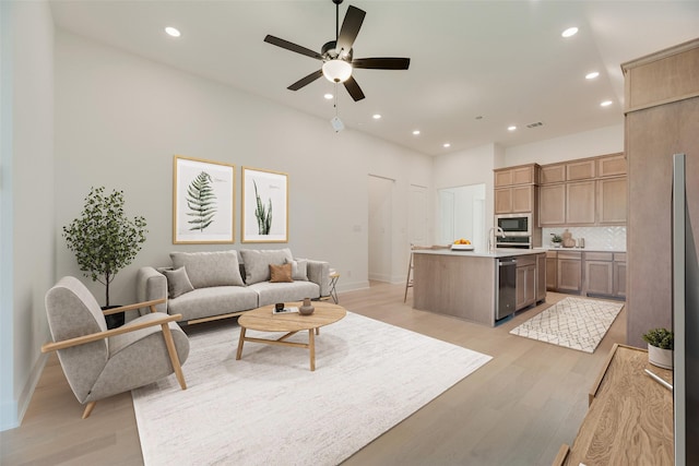 living area with recessed lighting, baseboards, a ceiling fan, and light wood-type flooring