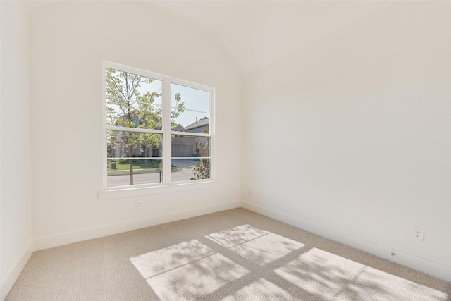 spare room with baseboards, carpet, and vaulted ceiling