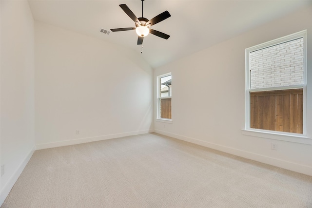 spare room featuring ceiling fan, visible vents, light carpet, and baseboards