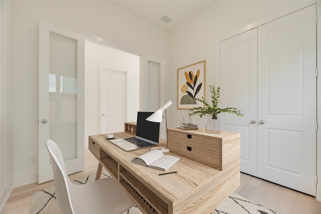 office with baseboards, visible vents, and light wood-style floors