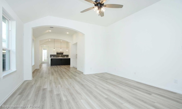 unfurnished living room featuring ceiling fan, light hardwood / wood-style flooring, and vaulted ceiling