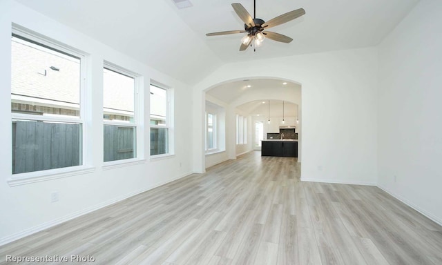 spare room with ceiling fan, light wood-type flooring, and lofted ceiling