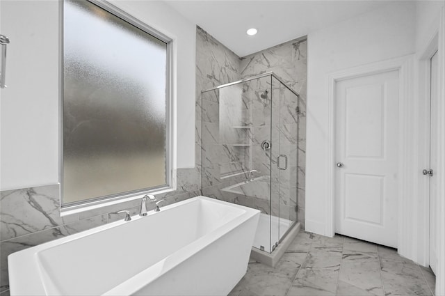 bathroom featuring a freestanding bath, marble finish floor, a marble finish shower, and recessed lighting