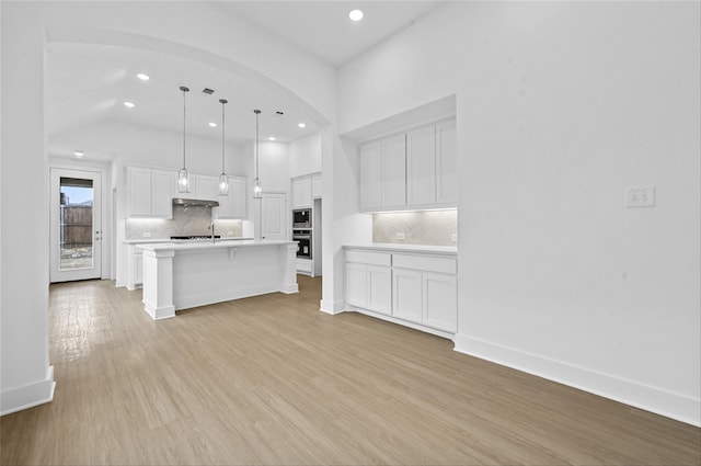 kitchen featuring light countertops, light wood-type flooring, white cabinetry, and baseboards