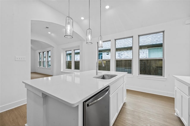 kitchen with dishwasher, light wood-style floors, a sink, and lofted ceiling