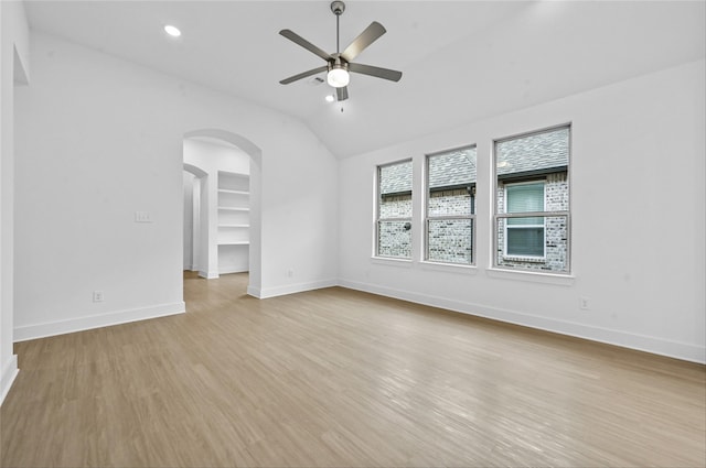 unfurnished room featuring arched walkways, recessed lighting, light wood-style flooring, ceiling fan, and baseboards