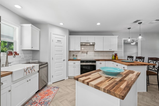 kitchen with wood counters, pendant lighting, white cabinetry, and a kitchen island