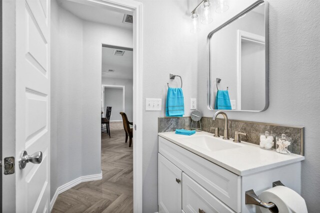 bathroom with vanity and parquet flooring