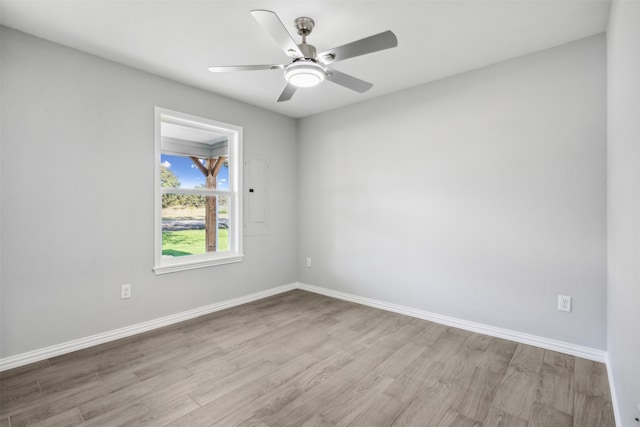 unfurnished room with electric panel, ceiling fan, and light hardwood / wood-style floors