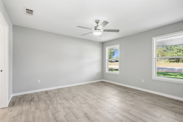 empty room with ceiling fan and light hardwood / wood-style flooring