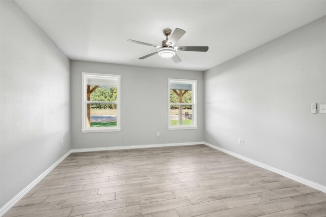 empty room with ceiling fan and light wood-type flooring