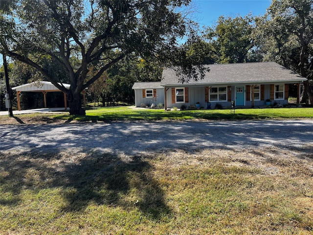 ranch-style house with a carport, a front yard, and covered porch