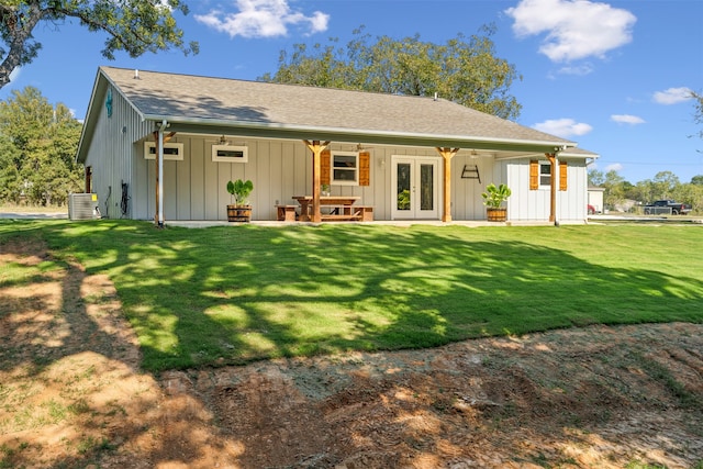 rear view of property featuring ceiling fan, cooling unit, a yard, and french doors