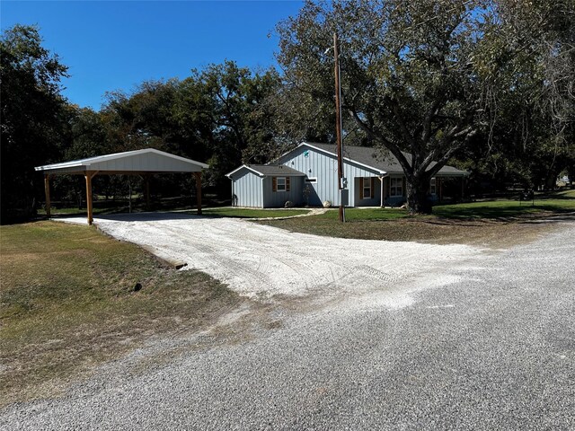 view of front of property featuring a carport, an outbuilding, and a front lawn