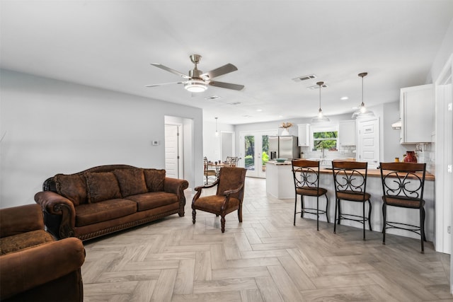 living room with ceiling fan and light parquet floors