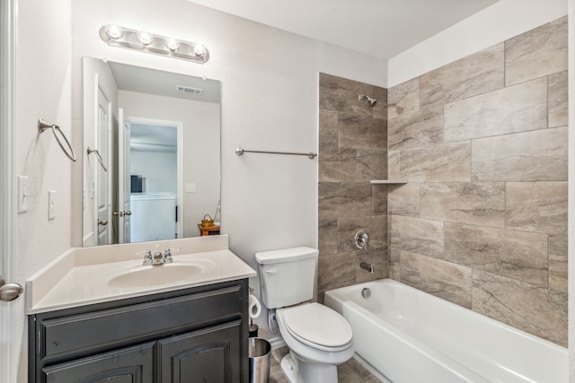 full bathroom featuring tiled shower / bath combo, toilet, and vanity