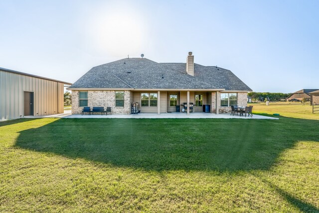 rear view of property with a lawn and a patio