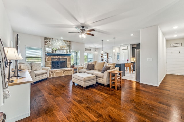 living room featuring dark hardwood / wood-style floors, ceiling fan, and a fireplace