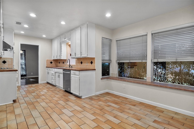 kitchen featuring extractor fan, decorative backsplash, white cabinetry, and stainless steel dishwasher