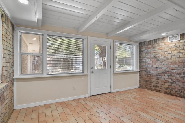 unfurnished sunroom featuring beamed ceiling