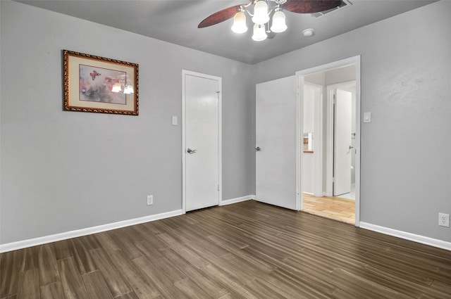 unfurnished bedroom with ceiling fan and dark wood-type flooring