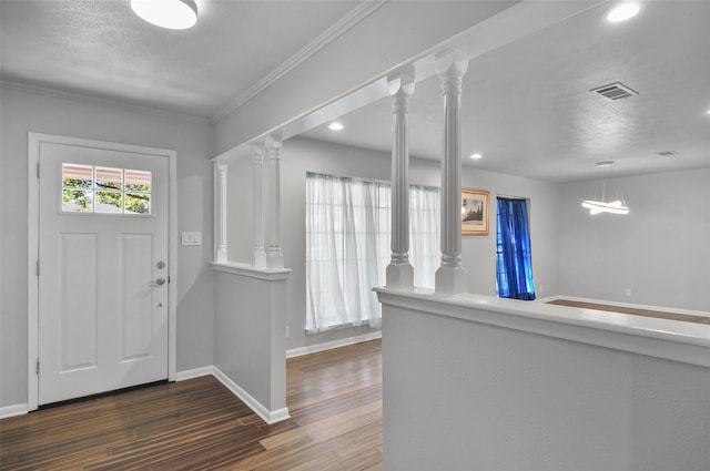 entryway featuring crown molding, ornate columns, and dark wood-type flooring