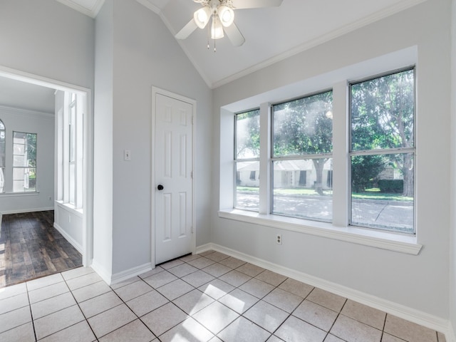 tiled empty room with crown molding, ceiling fan, and vaulted ceiling