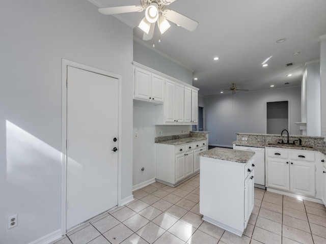 kitchen featuring white dishwasher, a kitchen island, and white cabinets