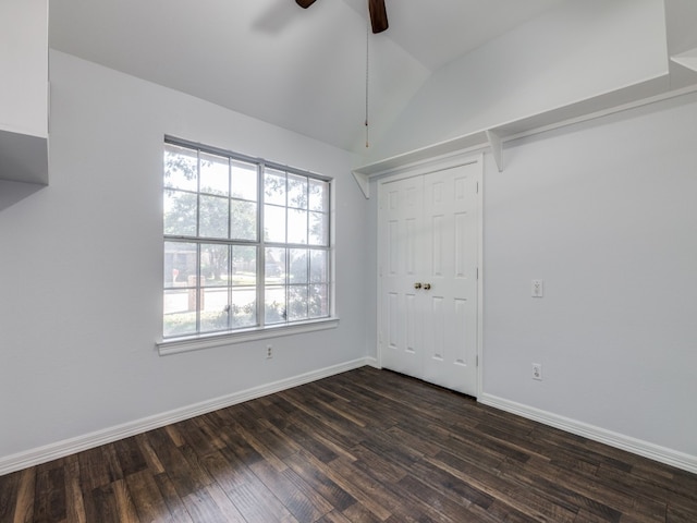 unfurnished bedroom with lofted ceiling, a closet, dark hardwood / wood-style floors, and ceiling fan