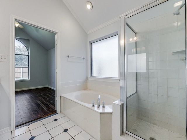 bathroom with vaulted ceiling, plenty of natural light, ornamental molding, and separate shower and tub