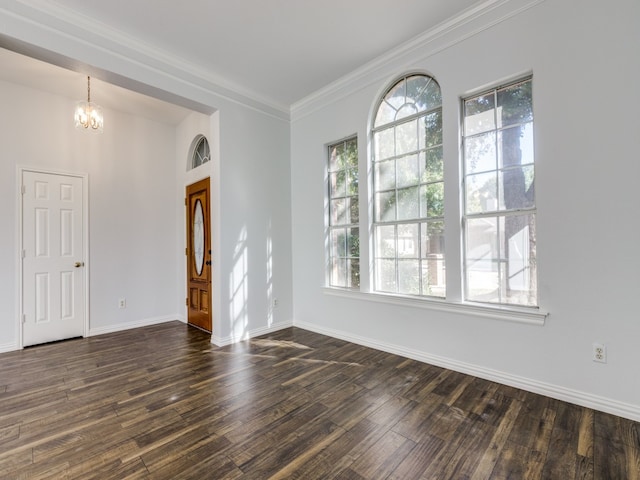 unfurnished room with dark wood-type flooring, ornamental molding, and a notable chandelier