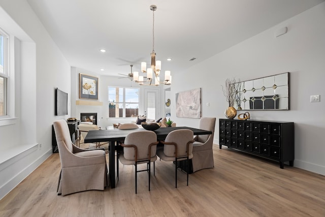 dining room featuring hardwood / wood-style flooring and ceiling fan with notable chandelier