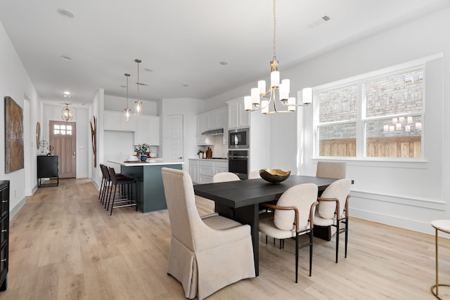 dining room featuring light hardwood / wood-style flooring and a notable chandelier