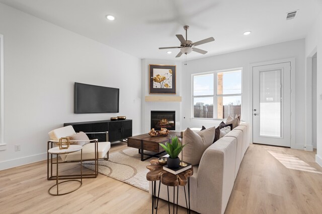 living room featuring ceiling fan and light hardwood / wood-style flooring