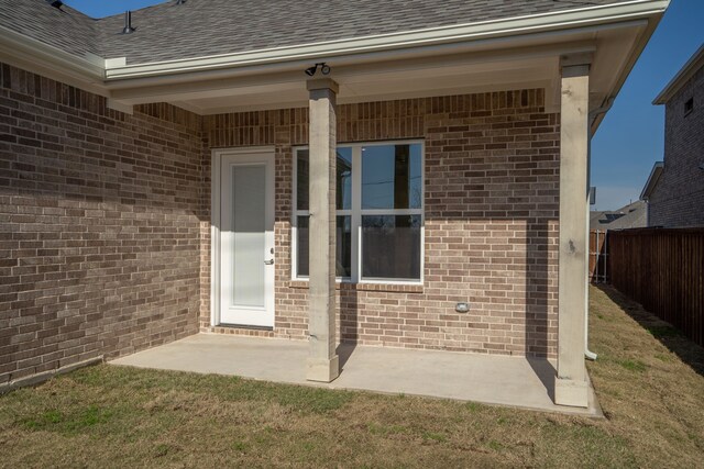 doorway to property with a lawn and a patio