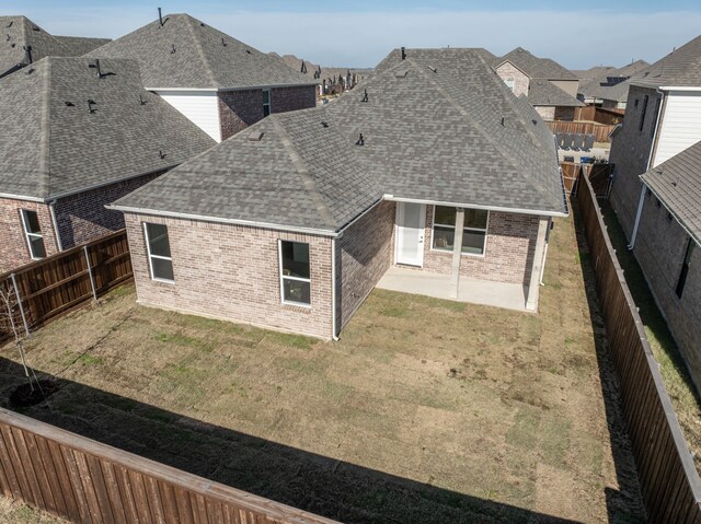 rear view of property featuring a lawn and a patio area