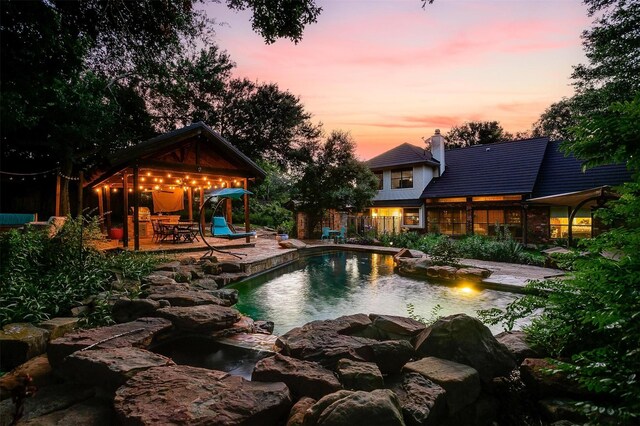 pool at dusk with a patio