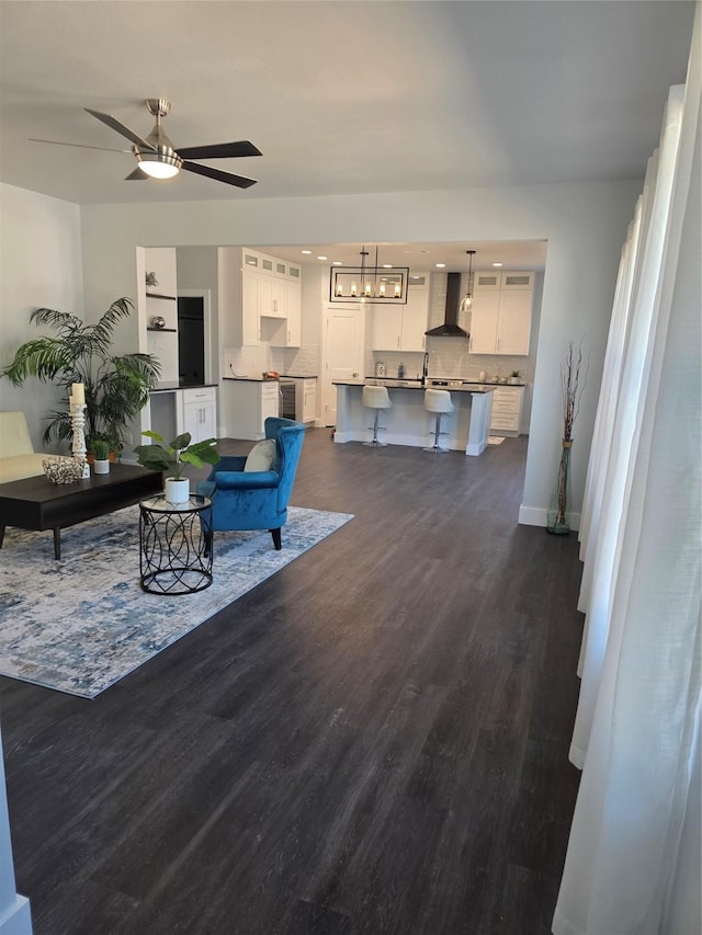3612 Broken Bow Dr, Granbury, TX 76048 - living room featuring dark wood-type flooring, a chandelier, baseboards, ceiling fan, and beverage cooler