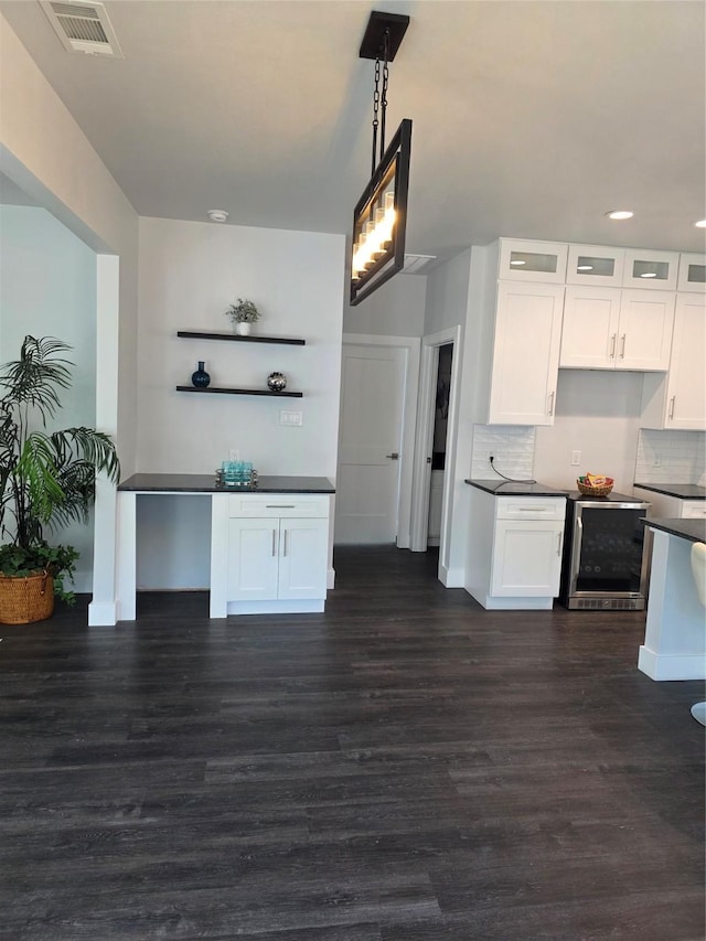 3612 Broken Bow Dr, Granbury, TX 76048 - kitchen featuring dark countertops, dark wood-type flooring, wine cooler, white cabinets, and decorative backsplash