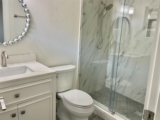 bathroom featuring vanity, toilet, and a shower with shower door