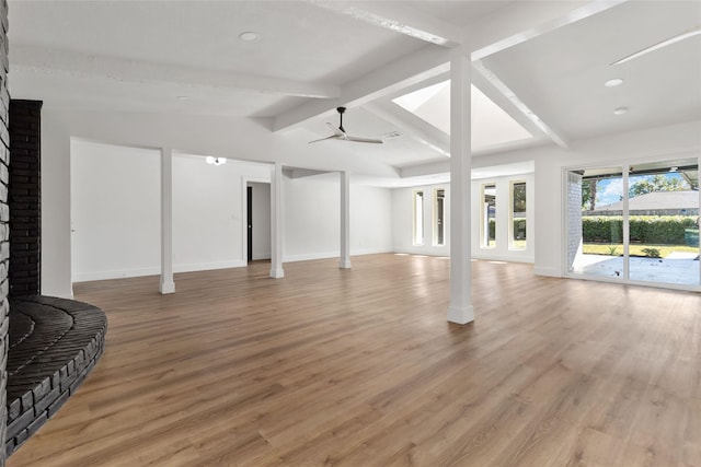 living room featuring lofted ceiling with beams, ceiling fan, and light wood-type flooring