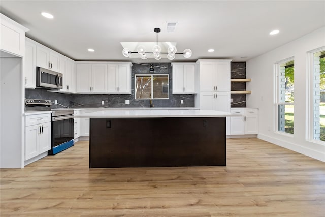 kitchen with pendant lighting, white cabinetry, and stainless steel appliances