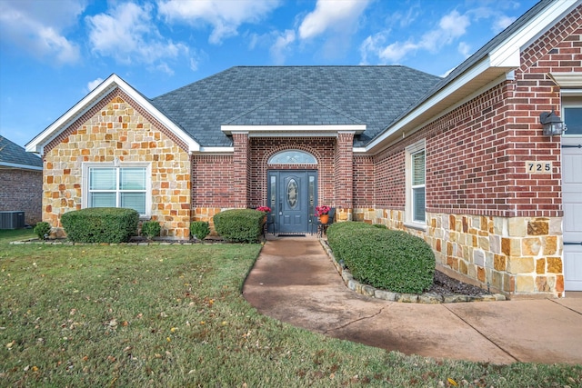 doorway to property with a yard and central AC