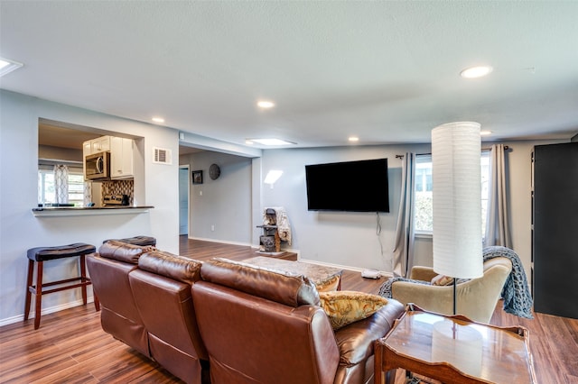 living room featuring light hardwood / wood-style floors and decorative columns