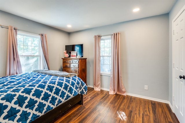 bedroom with dark hardwood / wood-style floors