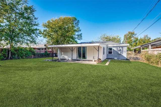 rear view of property with a yard and a patio area