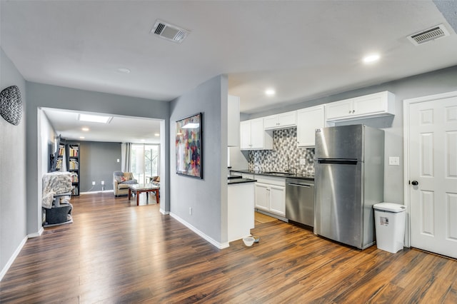 kitchen with tasteful backsplash, dark wood-type flooring, white cabinets, and appliances with stainless steel finishes